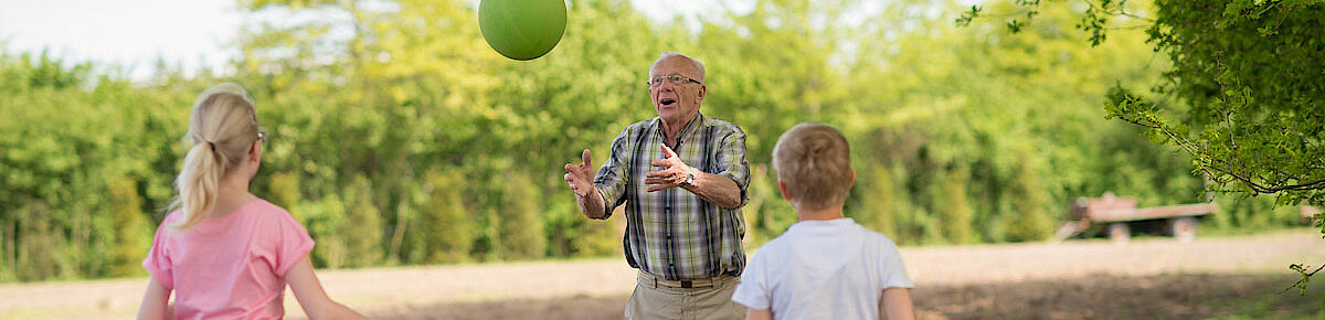 Ouderen man en kinderen spelen met bal